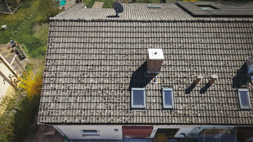 Drohnenansicht der bestehenden Dachfläche mit Dachfenstern und Schornstein vor dem Rückbau