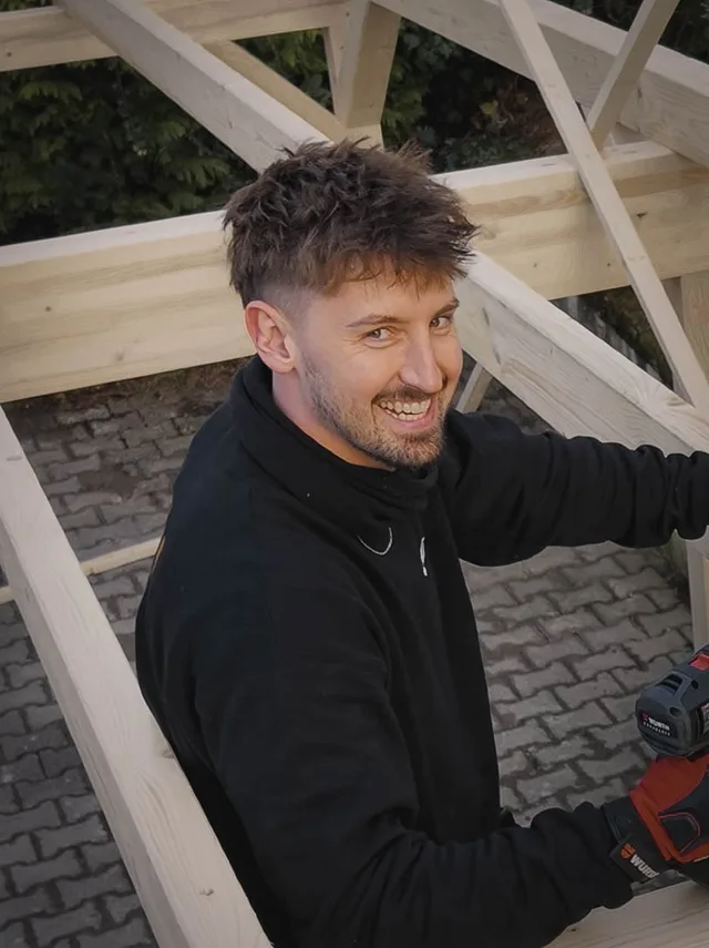 Jakob Wahr auf einer Baustelle inmitten einer Holzkonstruktion