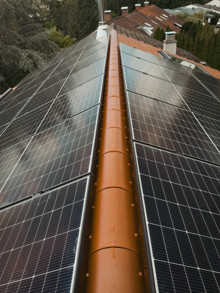 Blick entlang des Dachfirsts auf die großflächige Photovoltaikbelegung beider Dachseiten
